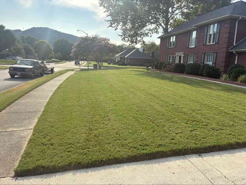 Fresh lawn with the Moore Lawncare work truck and mower trailer ready at the curb